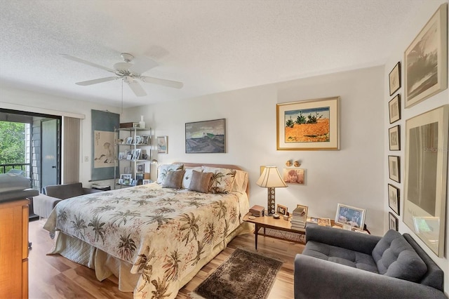 1088 Bird Bay Way Unit 307, Venice, FL 34285 - bedroom featuring access to outside, a textured ceiling, wood finished floors, and a ceiling fan