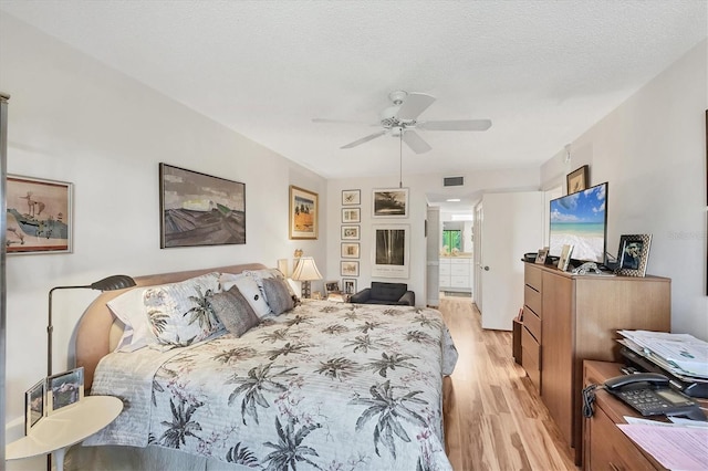 1088 Bird Bay Way Unit 307, Venice, FL 34285 - bedroom featuring light wood-type flooring, ceiling fan, and ensuite bathroom