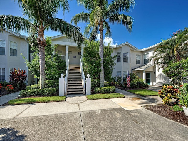 903 Addington Ct Unit 203, Venice, FL 34293 - view of front facade featuring stairs, stucco siding, and covered porch