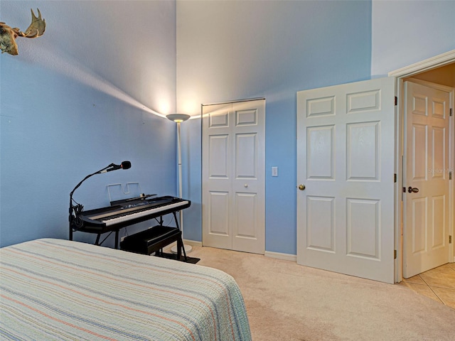 903 Addington Ct Unit 203, Venice, FL 34293 - bedroom featuring a towering ceiling, light carpet, and a closet