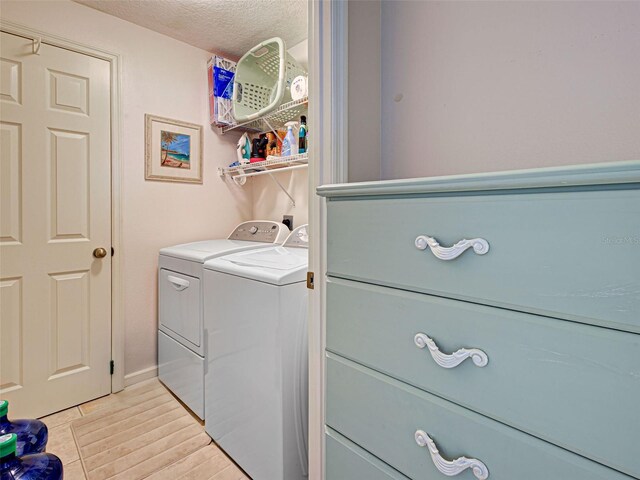 903 Addington Ct Unit 203, Venice, FL 34293 - washroom with washing machine and clothes dryer, a textured ceiling, and light wood finished floors