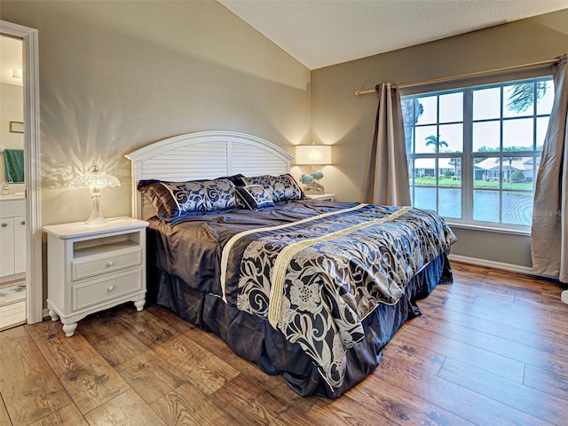 903 Addington Ct Unit 203, Venice, FL 34293 - bedroom featuring vaulted ceiling, hardwood / wood-style flooring, and ensuite bathroom