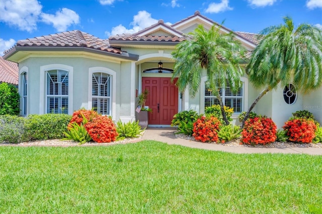 2471 Silver Palm Rd, North Port, FL 34288 - view of front facade with a front yard, a tiled roof, and stucco siding