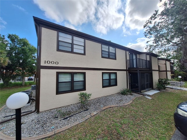 4022 Beaver Ln Unit 1000G, Port Charlotte, FL 33952 - view of side of property featuring a balcony, stucco siding, and a lawn