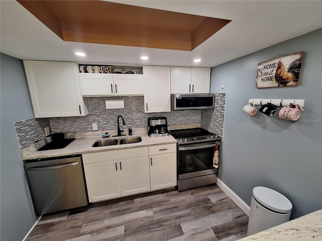 4022 Beaver Ln Unit 1000G, Port Charlotte, FL 33952 - kitchen with appliances with stainless steel finishes, wood finished floors, white cabinets, decorative backsplash, and recessed lighting