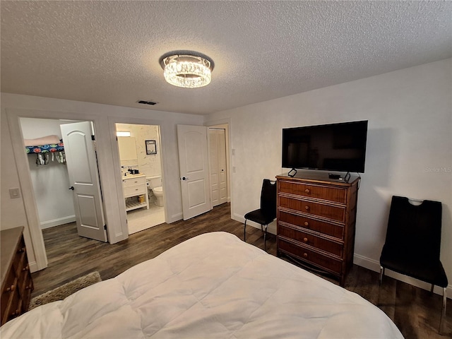 4022 Beaver Ln Unit 1000G, Port Charlotte, FL 33952 - bedroom with dark wood finished floors, a textured ceiling, a walk in closet, a chandelier, and ensuite bathroom