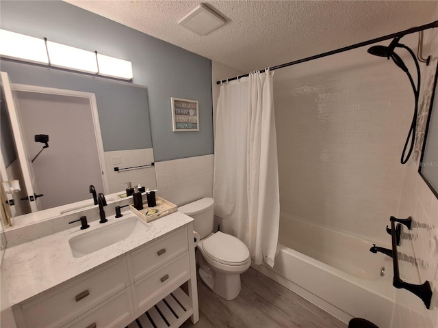 4022 Beaver Ln Unit 1000G, Port Charlotte, FL 33952 - bathroom with wood finished floors, vanity, a textured ceiling, shower / bath combo with shower curtain, and tile walls