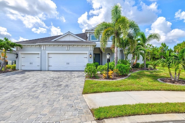 12301 Auburndale Ct, Venice, FL 34293 - view of front of home featuring decorative driveway, an attached garage, stucco siding, and a front yard