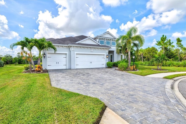 12301 Auburndale Ct, Venice, FL 34293 - view of front facade featuring decorative driveway, an attached garage, stucco siding, and a front yard
