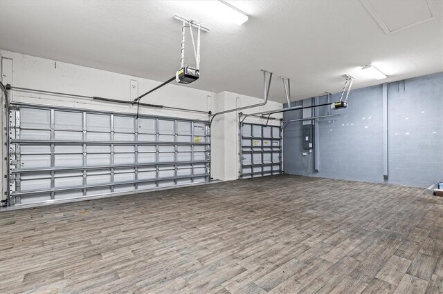 12301 Auburndale Ct, Venice, FL 34293 - garage featuring electric panel, a garage door opener, and concrete block wall