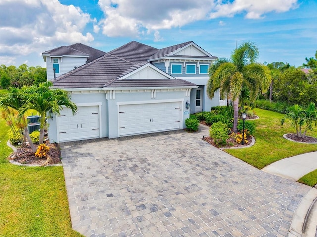 12301 Auburndale Ct, Venice, FL 34293 - traditional-style home featuring a garage, decorative driveway, a front yard, a tiled roof, and stucco siding