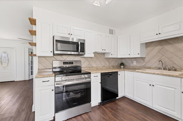 210 Duxbury Ave, Port Charlotte, FL 33952 - kitchen featuring appliances with stainless steel finishes, light countertops, tasteful backsplash, and white cabinetry