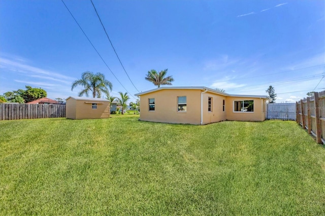 210 Duxbury Ave, Port Charlotte, FL 33952 - back of house with stucco siding, a fenced backyard, and an outbuilding