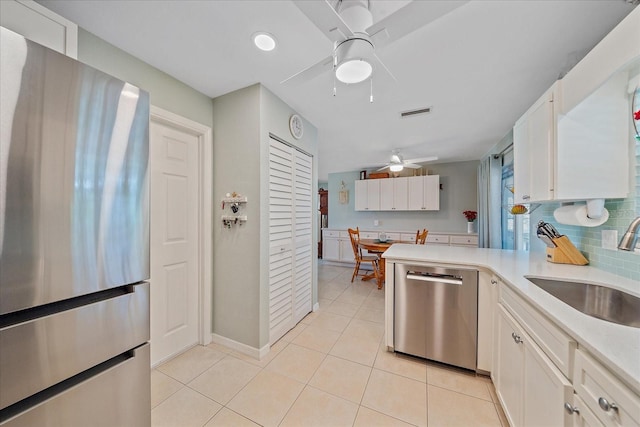10341 Greenway Ave, Englewood, FL 34224 - kitchen with stainless steel appliances, ceiling fan, light countertops, and white cabinets