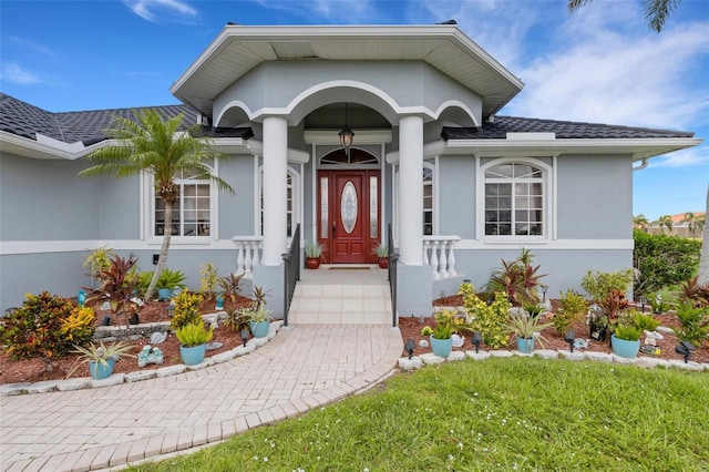 5001 Almar Dr, Punta Gorda, FL 33950 - property entrance with stucco siding, roof with shingles, and a yard