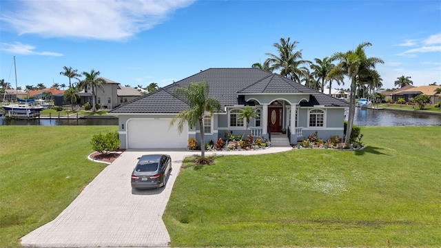 5001 Almar Dr, Punta Gorda, FL 33950 - mediterranean / spanish house featuring a garage, a water view, decorative driveway, and stucco siding
