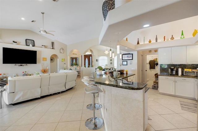 5001 Almar Dr, Punta Gorda, FL 33950 - kitchen featuring open floor plan, arched walkways, light tile patterned floors, ceiling fan, and high vaulted ceiling