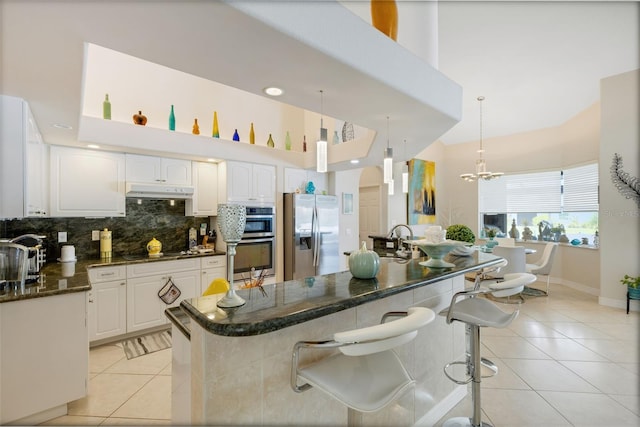 5001 Almar Dr, Punta Gorda, FL 33950 - kitchen with appliances with stainless steel finishes, light tile patterned floors, decorative backsplash, and white cabinetry
