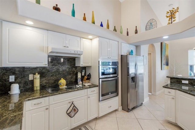 5001 Almar Dr, Punta Gorda, FL 33950 - kitchen with appliances with stainless steel finishes, under cabinet range hood, arched walkways, decorative backsplash, and light tile patterned flooring