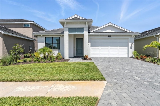 18525 Midsummer Pl, Venice, FL 34293 - view of front of house with decorative driveway, a garage, a front lawn, stucco siding, and a tiled roof