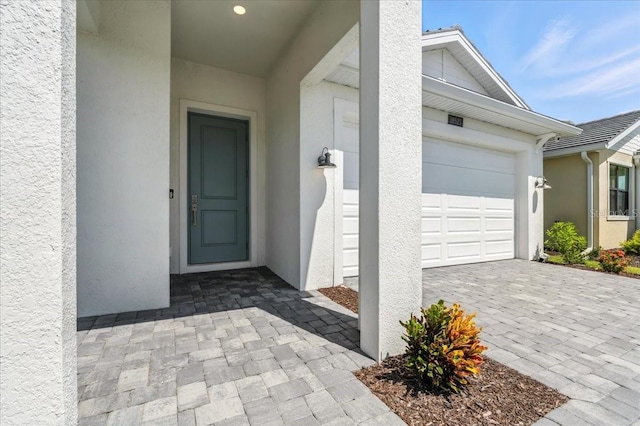 18525 Midsummer Pl, Venice, FL 34293 - property entrance with stucco siding and an attached garage