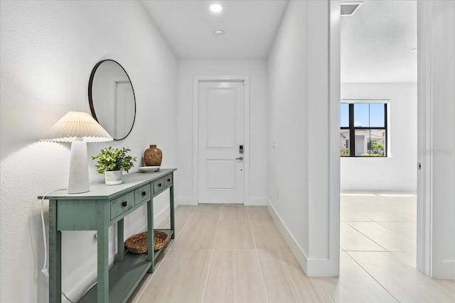18525 Midsummer Pl, Venice, FL 34293 - hallway featuring light tile patterned floors and baseboards
