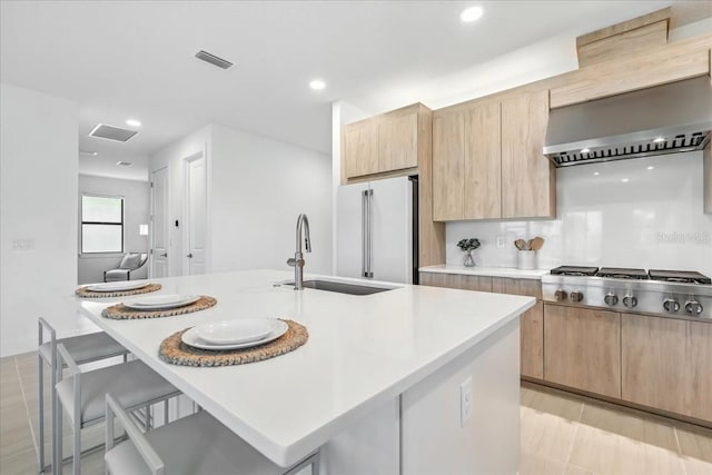 18525 Midsummer Pl, Venice, FL 34293 - kitchen with appliances with stainless steel finishes, light brown cabinetry, a kitchen breakfast bar, light countertops, and recessed lighting