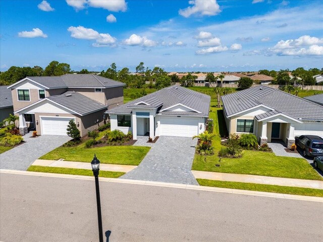18525 Midsummer Pl, Venice, FL 34293 - view of front of home featuring decorative driveway, a residential view, a tile roof, and an attached garage