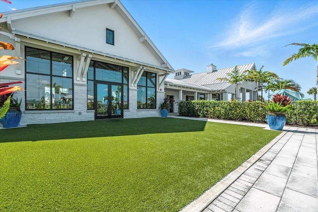 18525 Midsummer Pl, Venice, FL 34293 - rear view of property with a lawn, french doors, and stucco siding