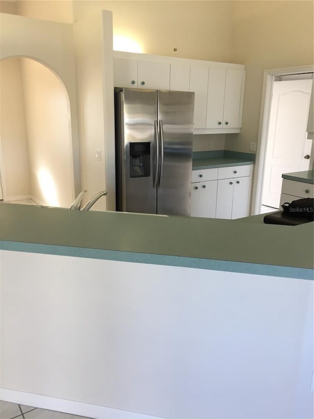 15140 Lyneburg Ave, Port Charlotte, FL 33981 - kitchen featuring stainless steel fridge with ice dispenser, white cabinetry, and arched walkways
