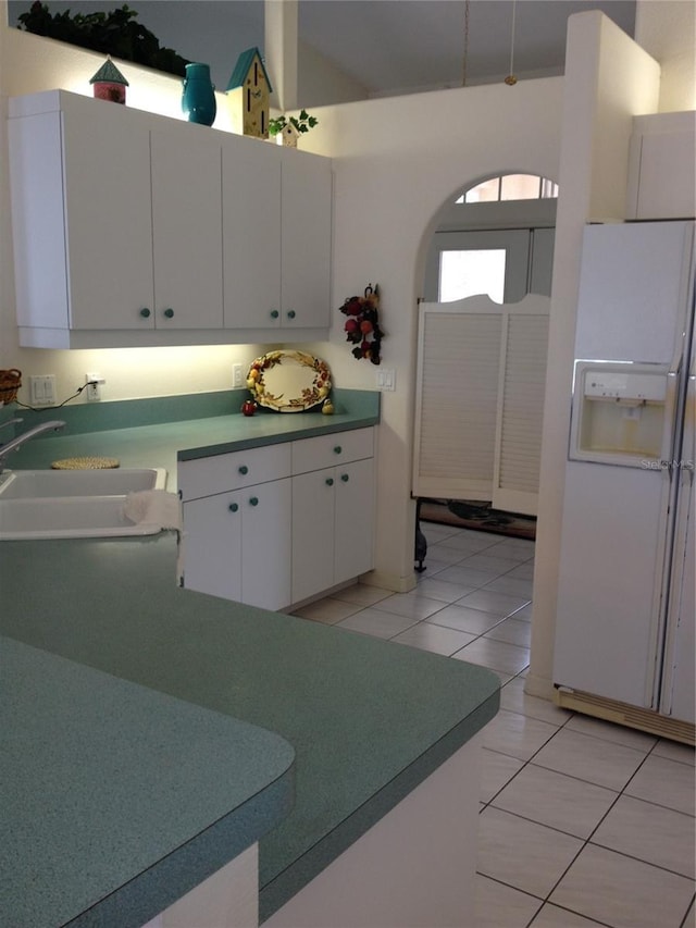 15140 Lyneburg Ave, Port Charlotte, FL 33981 - kitchen featuring white refrigerator with ice dispenser, white cabinetry, and light tile patterned floors