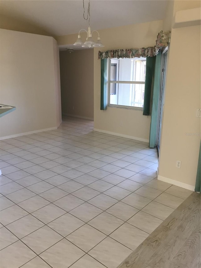 15140 Lyneburg Ave, Port Charlotte, FL 33981 - empty room with a chandelier and light tile patterned flooring