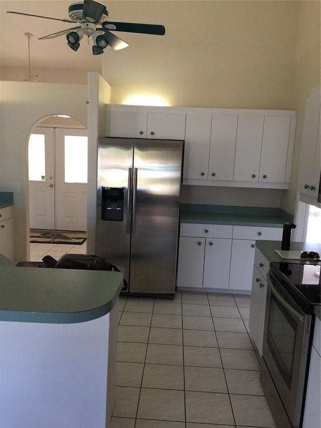 15140 Lyneburg Ave, Port Charlotte, FL 33981 - kitchen with appliances with stainless steel finishes, light tile patterned flooring, ceiling fan, white cabinets, and arched walkways