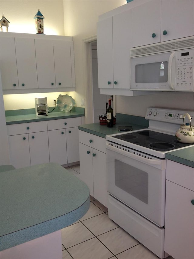 15140 Lyneburg Ave, Port Charlotte, FL 33981 - kitchen featuring white appliances, white cabinets, and light tile patterned flooring