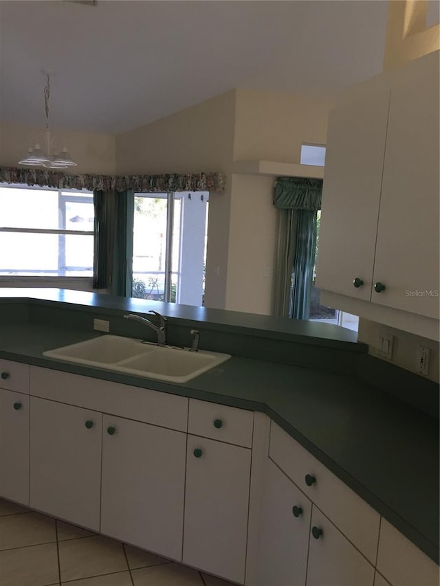 15140 Lyneburg Ave, Port Charlotte, FL 33981 - kitchen featuring dark countertops, white cabinetry, light tile patterned flooring, and vaulted ceiling