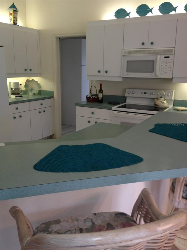 15140 Lyneburg Ave, Port Charlotte, FL 33981 - kitchen featuring white appliances and white cabinets