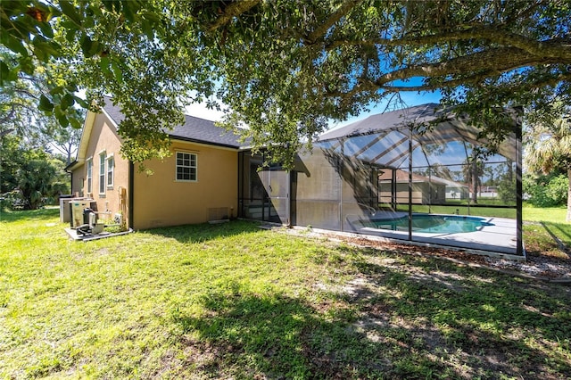 2631 S Cranberry Blvd, North Port, FL 34286 - rear view of house with stucco siding, a lawn, an outdoor pool, and glass enclosure