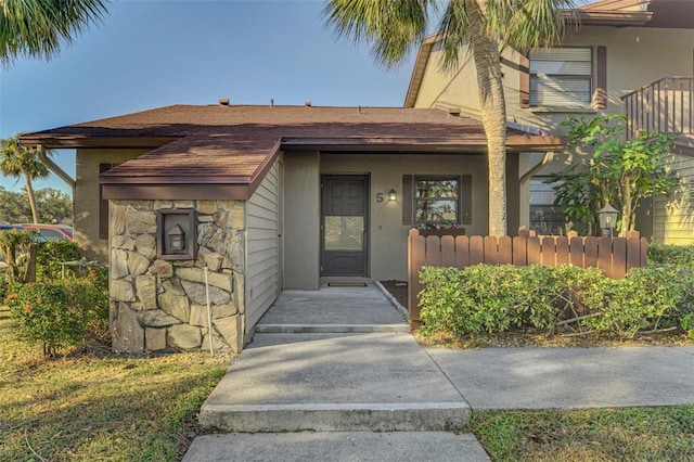 927 Capri Isles Blvd Unit 5, Venice, FL 34292 - property entrance featuring stone siding, stucco siding, and roof with shingles