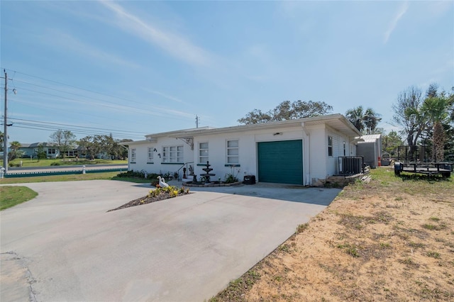 single story home featuring a garage and central AC unit