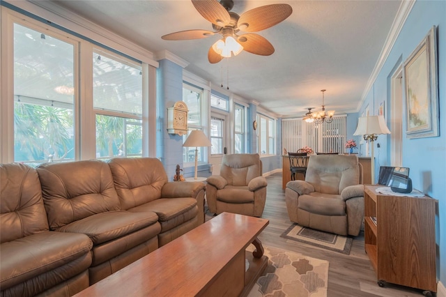 living room with ceiling fan with notable chandelier, hardwood / wood-style flooring, and ornamental molding