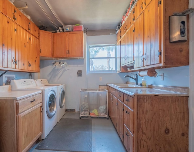 washroom with washer and clothes dryer, cabinets, and sink