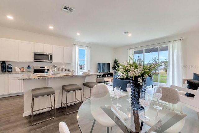 dining area with dark hardwood / wood-style floors, a healthy amount of sunlight, and sink