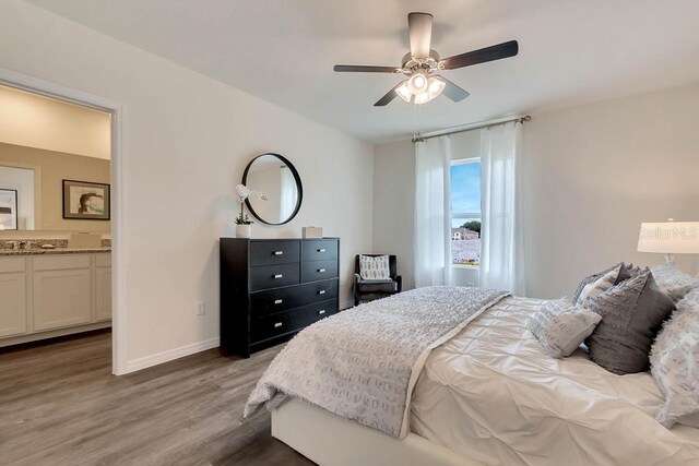 bedroom featuring ensuite bathroom, ceiling fan, and hardwood / wood-style flooring