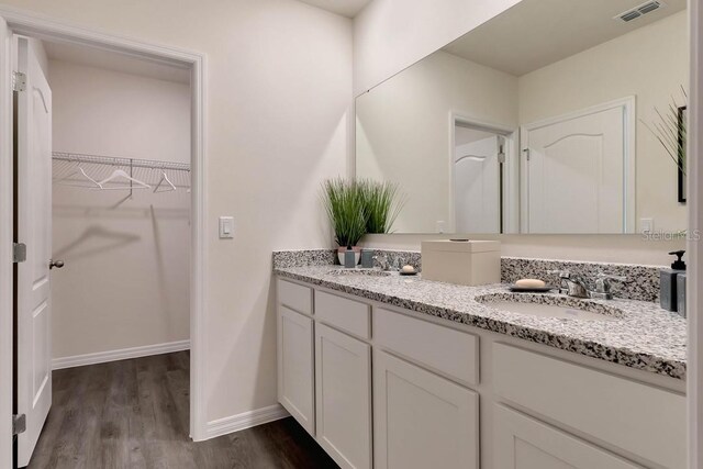 bathroom with double sink vanity and hardwood / wood-style flooring