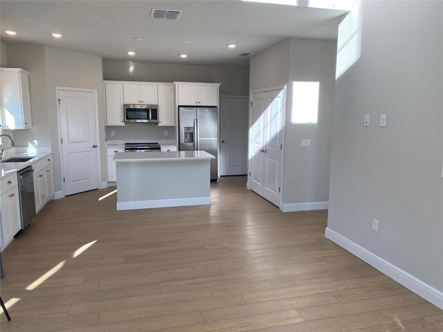 kitchen with visible vents, white cabinets, appliances with stainless steel finishes, a center island, and light countertops