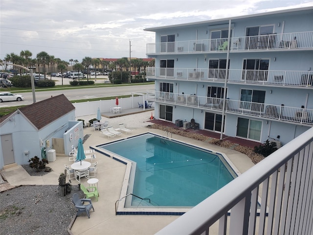 view of swimming pool with central air condition unit and a patio area