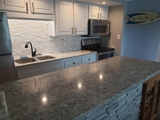 kitchen featuring backsplash, stainless steel appliances, white cabinetry, and sink