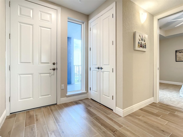 doorway featuring ceiling fan and light hardwood / wood-style flooring