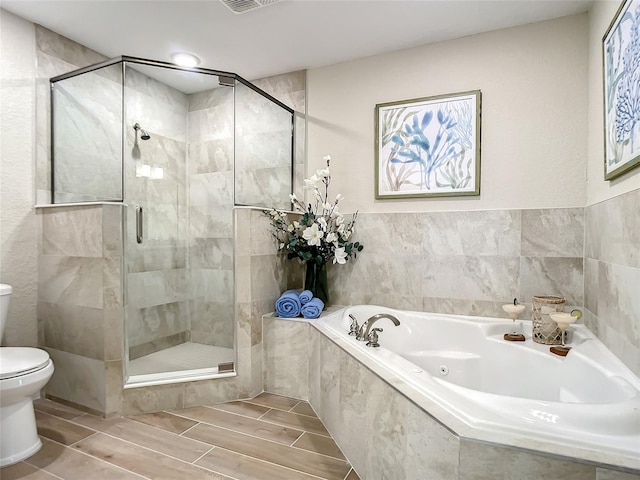 bathroom with tile floors, independent shower and bath, and toilet