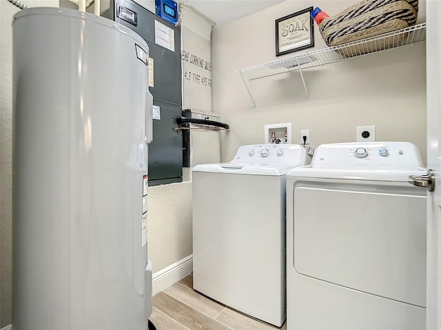 washroom featuring hookup for an electric dryer, light hardwood / wood-style flooring, electric water heater, hookup for a washing machine, and washer and dryer